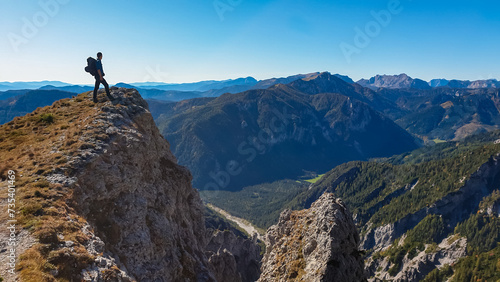 Hiker man standing on mountain summit with panoramic view of majestic Hochschwab massif, Styria, Austria. Idyllic hiking trail in remote Austrian Alps. Sense of escapism, peace, personal reflection © Chris