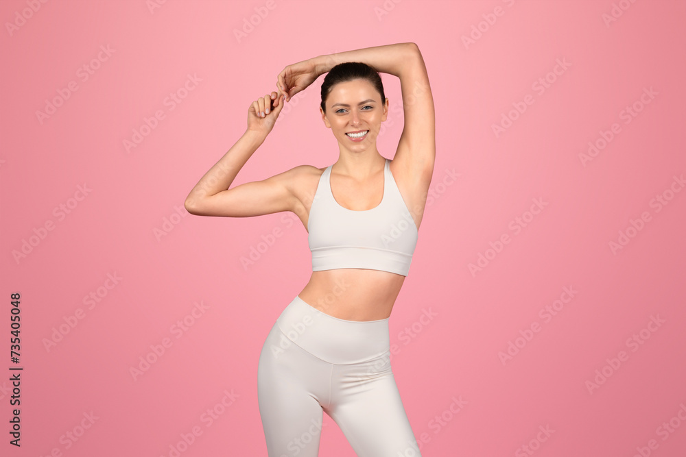 Confident and fit, a woman in a white sports bra and leggings stretches her arms Confident and fit, a woman in a white sports bra and leggings stretches her arms