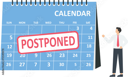 Business people look a postponed rubber stamp on a calendar or canceling event concept,
 photo