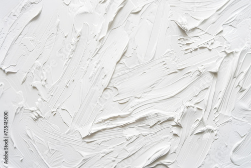 Close-up of a white textured surface with thick, expressive brush strokes and paint smears creating depth. photo