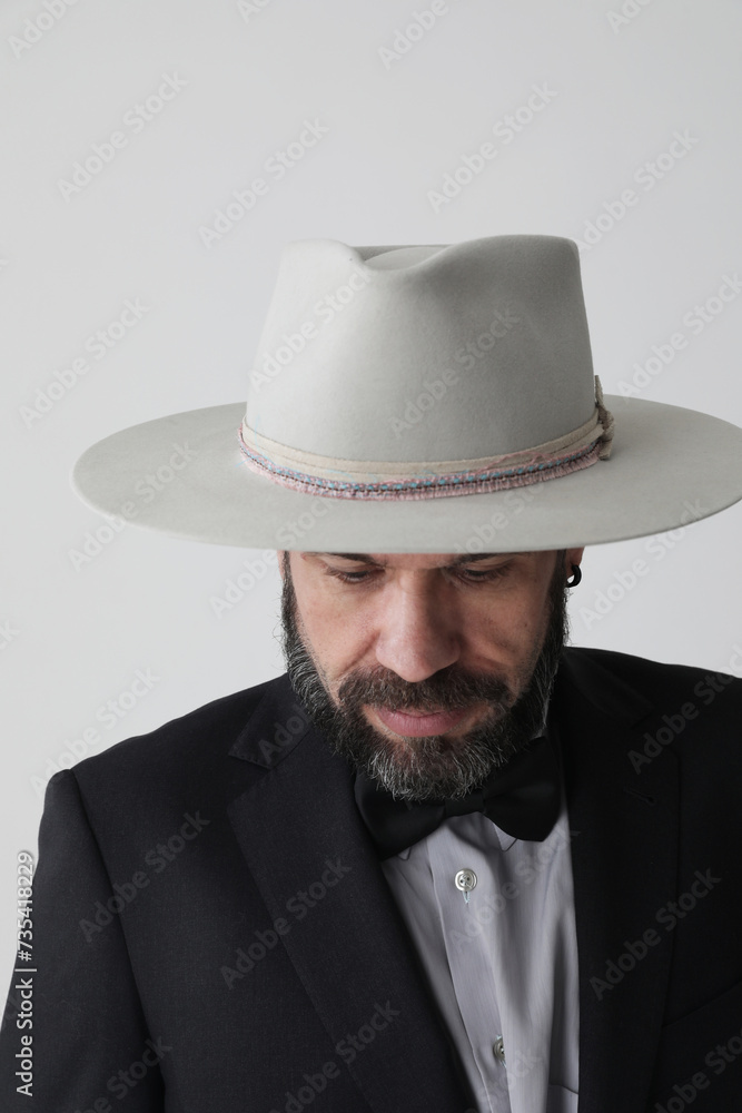 Vertical portrait of man wearing hat looking away and poses at the studio. Vertical portrait of man wearing hat looking away and poses at the studio.