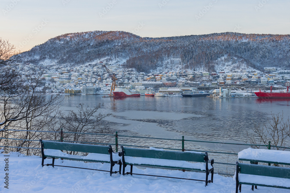 South part of bay of Bergen in early morning of winter. Sun slowly rising behind the mountains revealing suburbs of Laksevåg and Damsgard