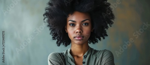 Confident young woman with stunning black afro hairs looking at camera with style and beauty