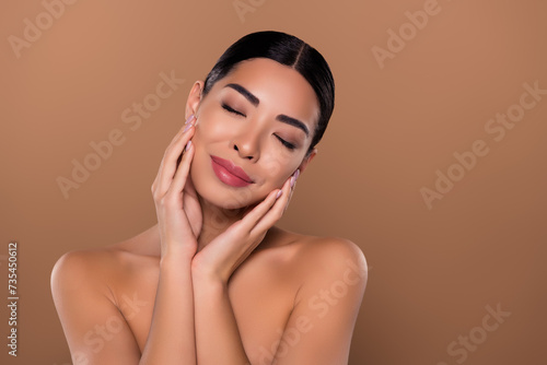 Photo of adorable tender nude girl closed eyes peeling collagen makeup empty space isolated on beige color background