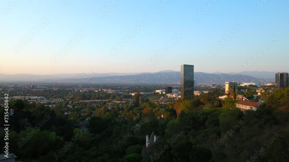 Aerial Scenic Shot Of Green Trees In Residential City Against Clear Sky, Drone Flying Backwards Over Luxurious Hotel Balcony - Los Angeles, California Aerial Scenic Shot Of Green Trees In Residential City Against Clear Sky, Drone Flying Backwards Over Luxurious Hotel Balcony - Los Angeles, California