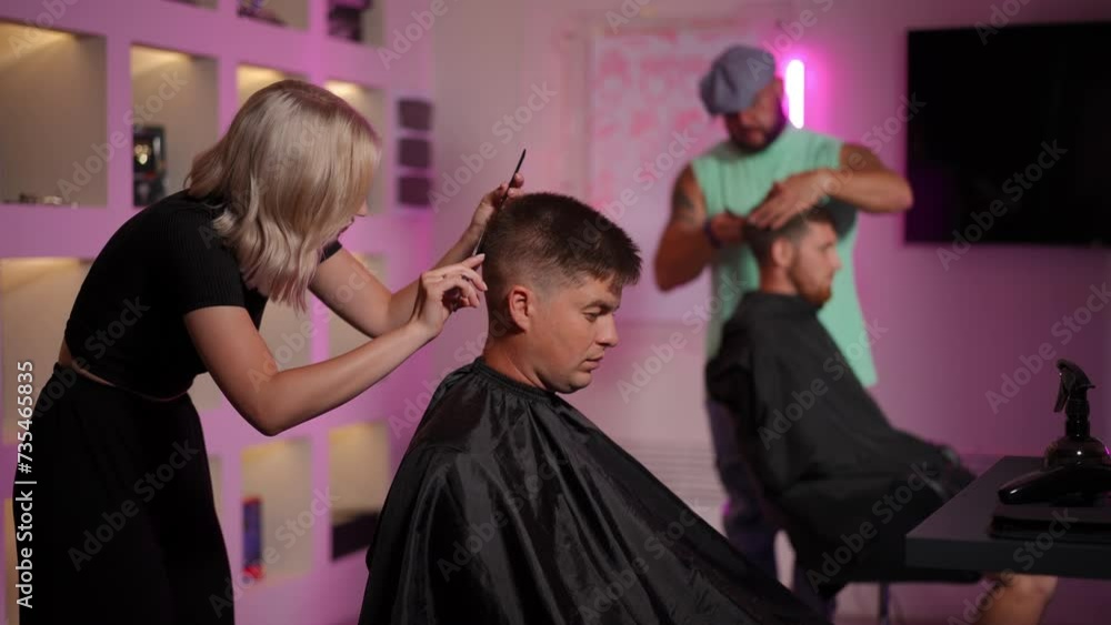 Work of professional hairdressers in a modern hair salon. Hairdressers cut their clients' hair using a comb and hairdressing scissors. Slow motion Work of professional hairdressers in a modern hair salon. Hairdressers cut their clients' hair using a comb and hairdressing scissors. Slow motion