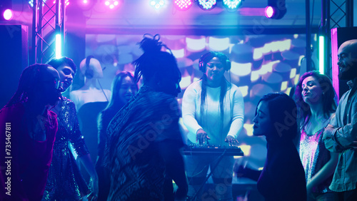 Happy people dancing on funky music  men and women preparing for dance battle on the dance floor. Young group of friends having fun showing off breakdance moves and skills. Tripod shot.