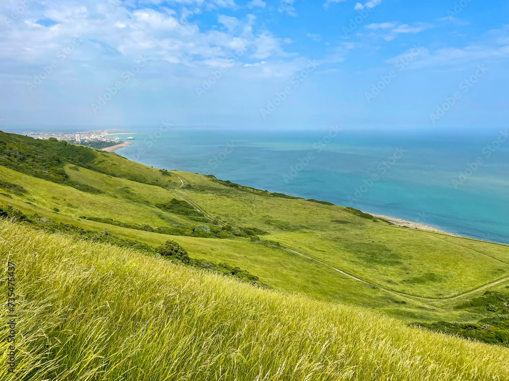 Picturesque green hilly coastline of South England above the turquoise blue sea Picturesque green hilly coastline of South England above the turquoise blue sea