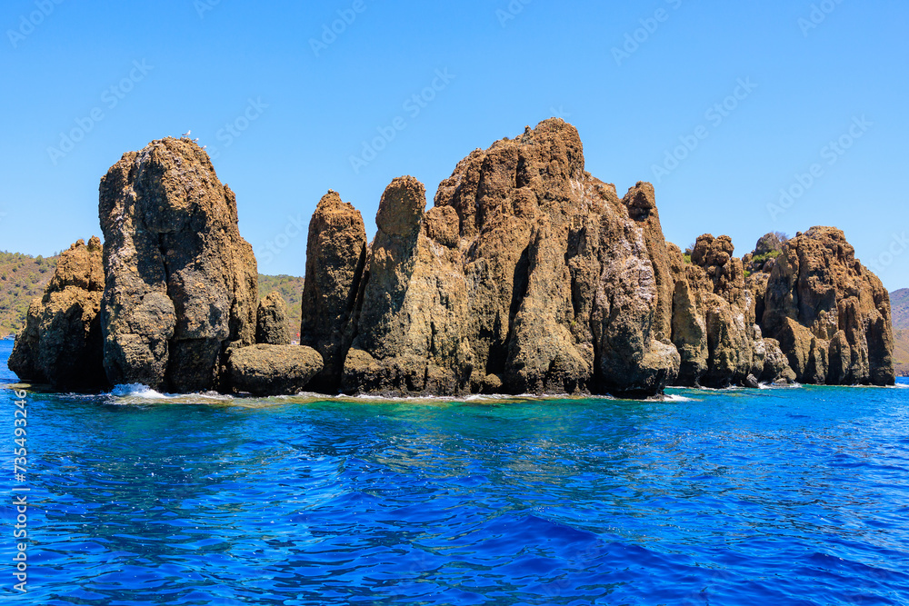 Rocky coast in the resort part of the Mediterranean or Aegean Sea. Background with selective focus and copy space