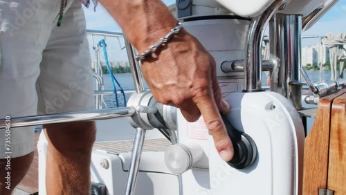 Seasoned yachtsman uses throttle lever to decrease speed. Skilled sailor prepares right conditions for maneuvering sailboat