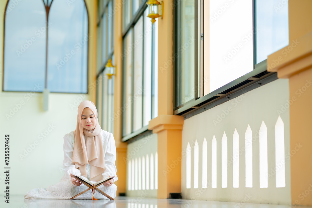 Ramadan, quran, The image of an Asian Muslim woman in the Islamic religion in hijab in cream color. reading the Quran and having a happy Staying in a beautiful mosque, Arabic word Holy Al Quran. Ramadan, quran, The image of an Asian Muslim woman in the Islamic religion in hijab in cream color. reading the Quran and having a happy Staying in a beautiful mosque, Arabic word Holy Al Quran.