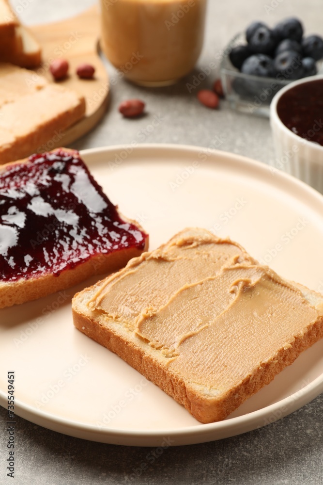 Tasty peanut butter sandwiches with jam on gray table, closeup Tasty peanut butter sandwiches with jam on gray table, closeup