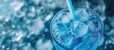 Refreshing blue soda drink in a clear glass with ice cubes on a hot summer day