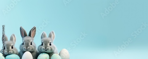 Cute little rabbit and Easter eggs on pastel blue background. Easter holiday concept. Funny pet for design greeting card, banner, flyer, invitation with copy space