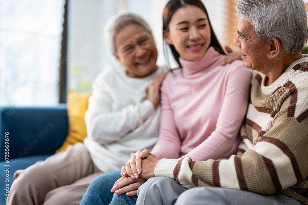 Asian senior elderly couple sit on sofa with young daughter in house. Asian senior elderly couple sit on sofa with young daughter in house.