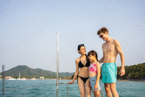 Caucasian happy family standing on deck of yacht while yachting outdoor.  © Kawee