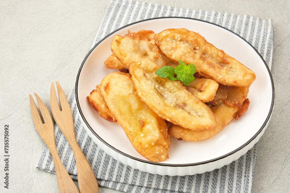 Pisang Goreng Wijen or banana fritters with sesame seed served in white plate. Indonesian food
Pisang Goreng Wijen or banana fritters with sesame seed served in white plate. Indonesian food