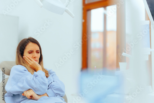 Unhappy Patient Suffering from a Tooth Ache in a Dental Office. Woman in discomfort situation from wisdom molar infection requiring medical help
