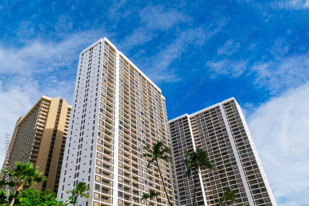 Exterior view of modern high rise residential buildings framed by lush palm trees