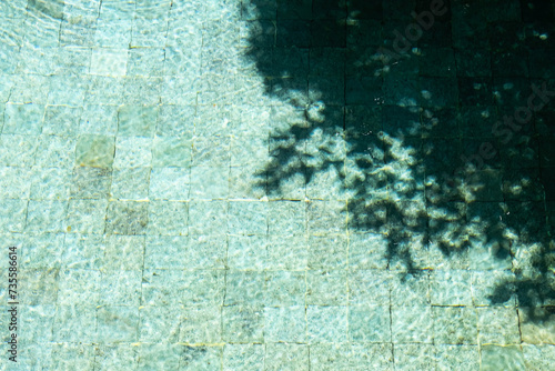 Water surface In swimming pool with sunny reflections and shadows.