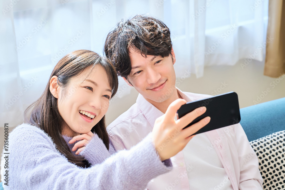 スマートフォンの画面を見ている若い男女 スマートフォンの画面を見ている若い男女