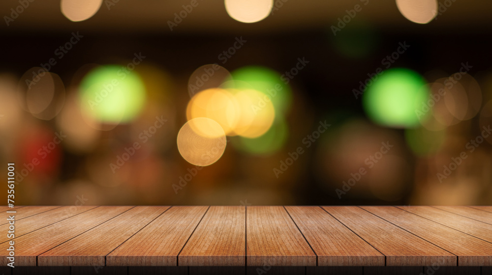 Empty wooden table top with lights bokeh on blur restaurant background.