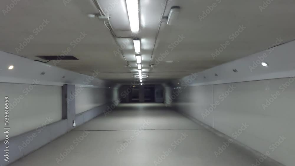 A passage through a long, dark corridor with lamps A passage through a long, dark corridor with lamps