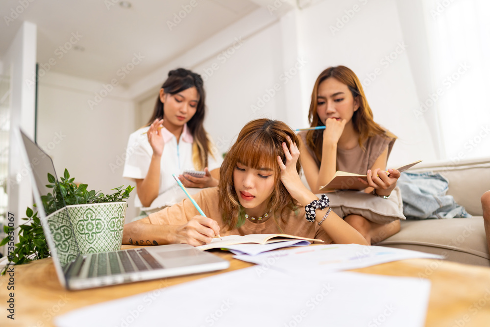 Group of Young Asian woman university college student using laptop computer and tablet for research study brainstorming discussion learning analyze ideas making project report together in living room Group of Young Asian woman university college student using laptop computer and tablet for research study brainstorming discussion learning analyze ideas making project report together in living room
