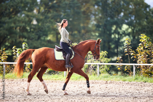 Foto Horse woman rider riding in the sunshine at the riding arena.