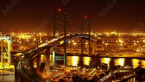 Aerial Panning Shot Of Illuminated Vincent Thomas Bridge Over Inlet In Sparkly City Against Clear Sky At Night - San Pedro, California photo