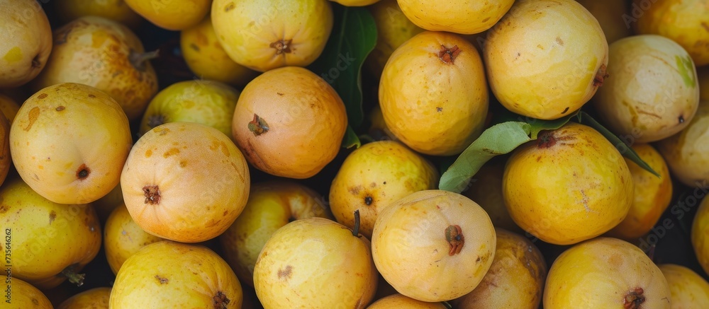 Abundant pile of ripe and vibrant yellow fruits with fresh green leaves, organic healthy food concept