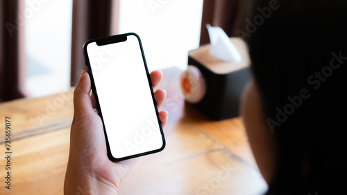 Close-up male office worker or employee using his smartphone at his office desk. smartphone white screen mockup