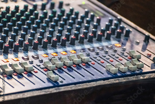 Sound engineer using mixing console to produce a sound track.