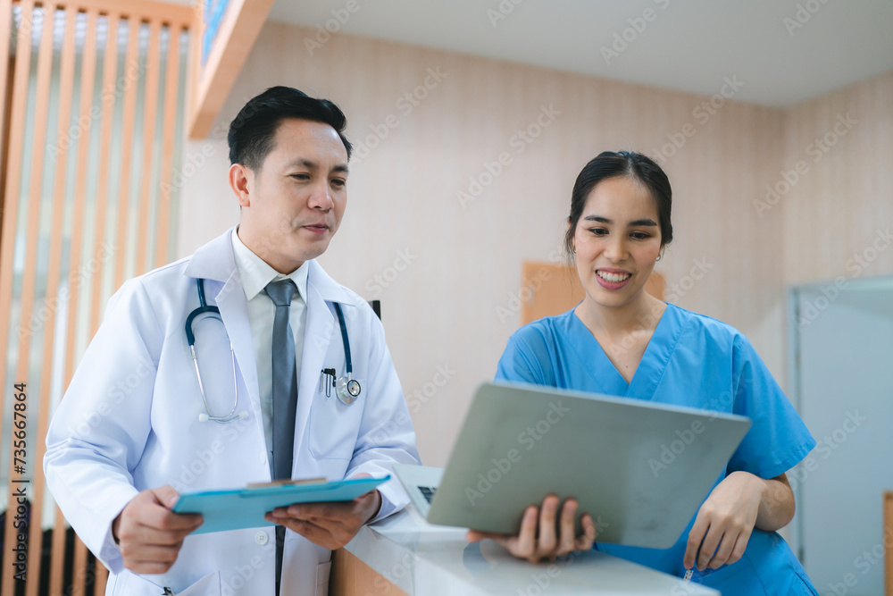 Mature female doctor discussing medical report with nurses in hospital hallway. Senior general practitioner discussing patient case status with group of medical staff after surgery. Doctors working. Mature female doctor discussing medical report with nurses in hospital hallway. Senior general practitioner discussing patient case status with group of medical staff after surgery. Doctors working.