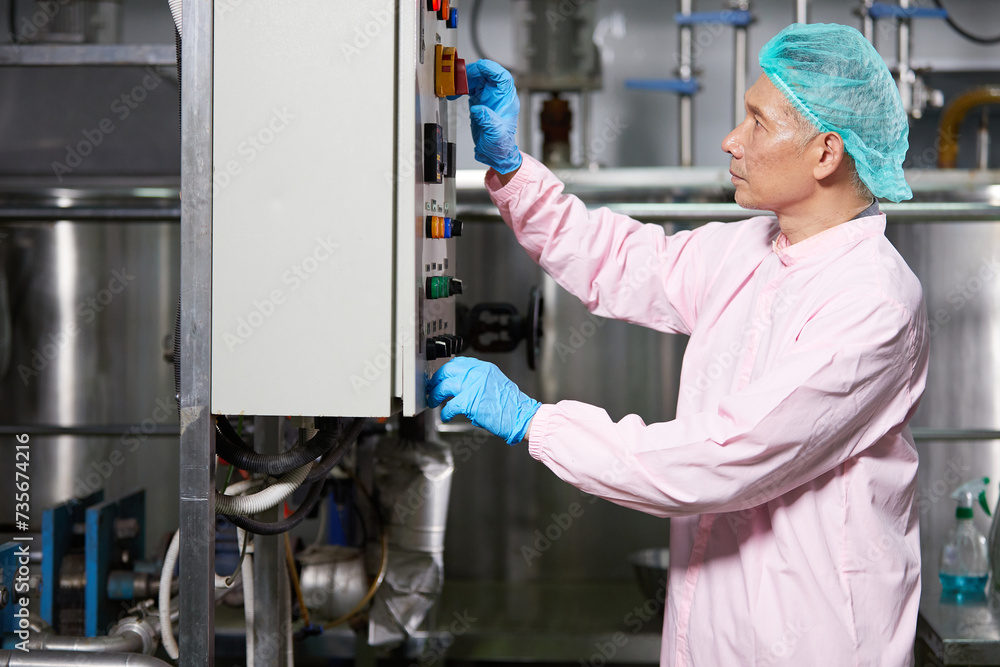 senior worker working at machine control panel in the factory senior worker working at machine control panel in the factory