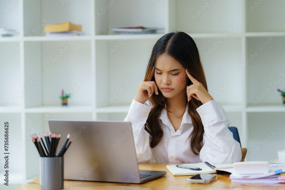 Asian businesswomen are serious at work causing headaches and stressed out with documents with a laptop at the office. Asian businesswomen are serious at work causing headaches and stressed out with documents with a laptop at the office.