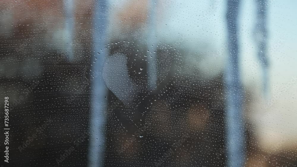 Heart shape on a foggy window against the background of icicles and winter city. Heart shape on a foggy window against the background of icicles and winter city.