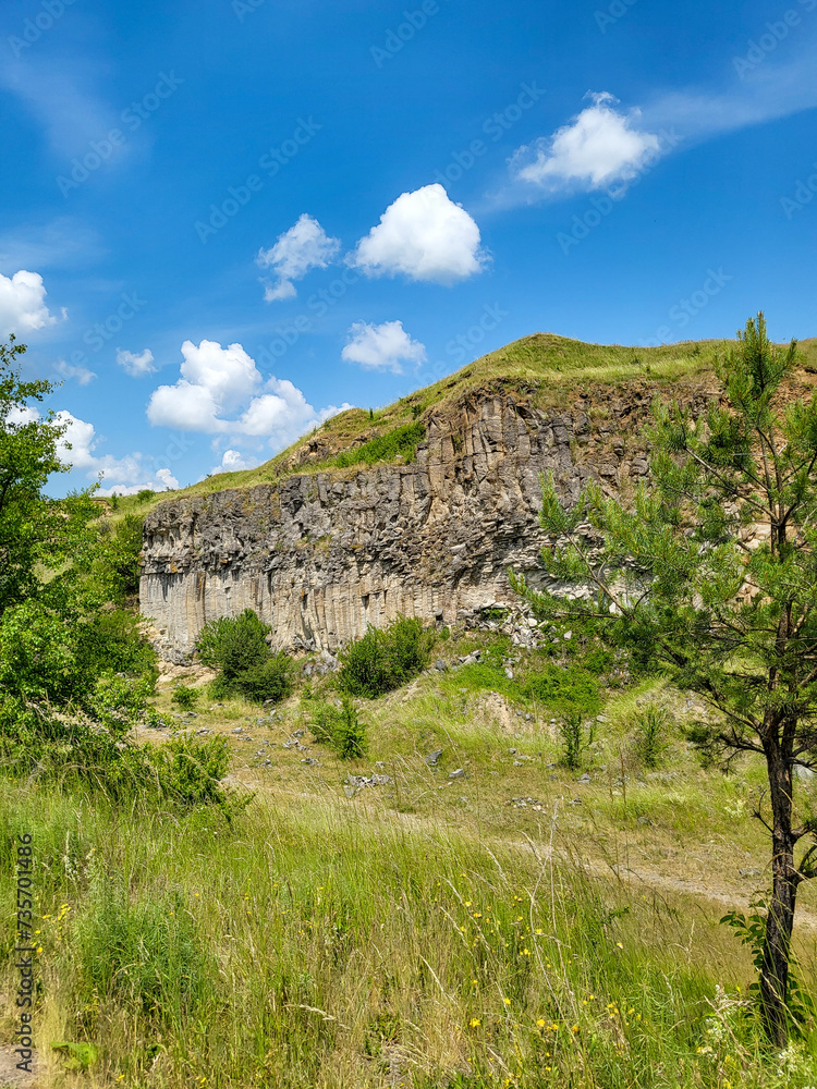 The basalt columns of Racos, Coloanele de bazalt de la Racos, stone wall in nature with blue sky, Racos, Brasov, Transylvania, Romania