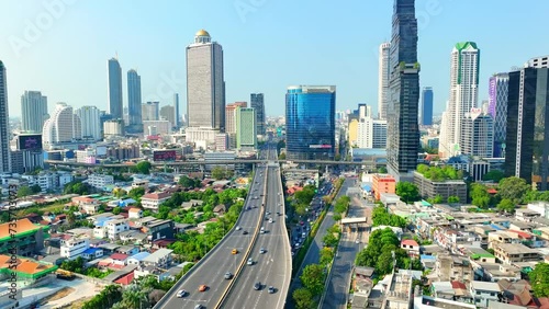 4K - Bangkok Thailand: Drone Aerial view, Over the urban sprawl, the drone hovers, a silent sentinel above towering skyscrapers and high rises, witnessing the heartbeat of the metropolis. 
 photo