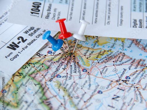 Closeup low angle view of blue red and white colors of the United States flag push pins tacks pining Washington DC with tax forms in background for tax returns filing reminder which are due in April