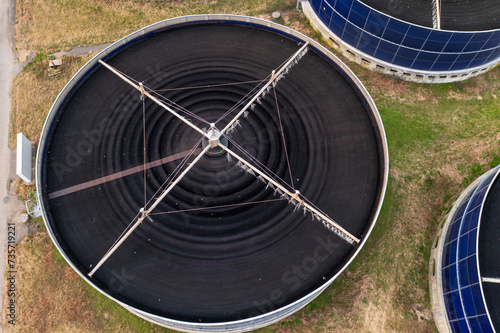 Aerial top view of massive round water tank for water filtration in water treatment plant.