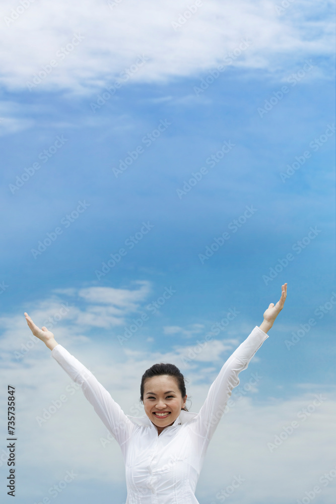 Conceptual image of an Asian woman with arms raised in celebration Conceptual image of an Asian woman with arms raised in celebration