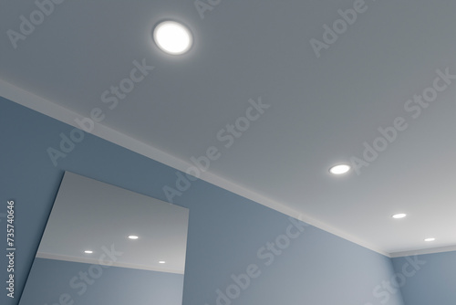 Recessed ceiling lights in a white stretch ceiling. photo