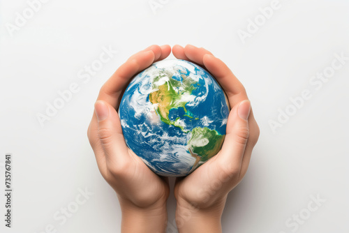 Miniature planet Earth in hand against a background of grass sky and sun