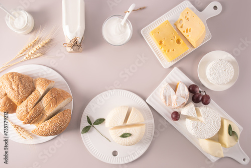 A set of various fresh dairy products and traditional bread for the Jewish Shavuot holiday on a pastel background. Top view. Flat lay