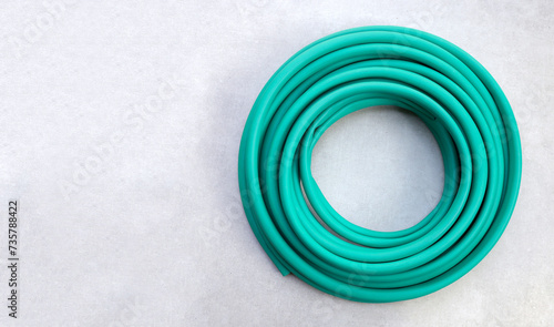 Tableau sur toile Green garden hose on cement floor background.
