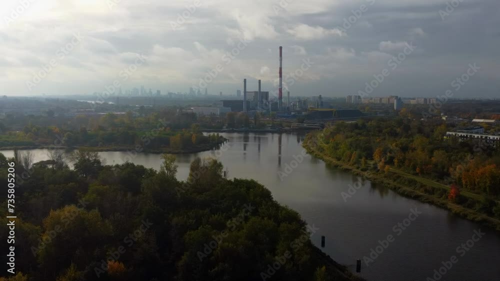 An aerial view of a heat supply and power plant, environmental impacts of coal energy, with power plant chimneys visible on the horizon against the backdrop of a cityscape. An aerial view of a heat supply and power plant, environmental impacts of coal energy, with power plant chimneys visible on the horizon against the backdrop of a cityscape.