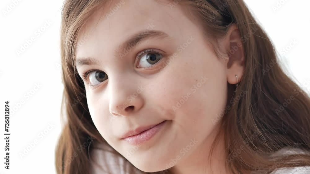 Portrait of a pretty little school-age girl with big wide-open green eyes looking into the frame, a curious look, freckles on her cheeks, curly dark hair. Portrait of a pretty little school-age girl with big wide-open green eyes looking into the frame, a curious look, freckles on her cheeks, curly dark hair.
