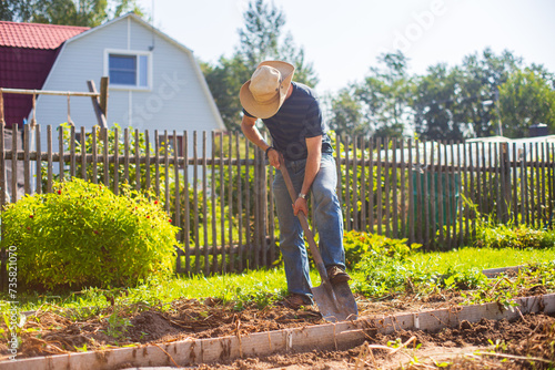 The farmer digs the soil in the vegetable garden. Preparing the soil for planting vegetables. Gardening concept. Agricultural work on the plantation