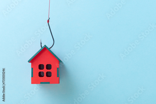 House on a Fish Hook over blue background with copy space, Concept of Real Estate Investment Danger